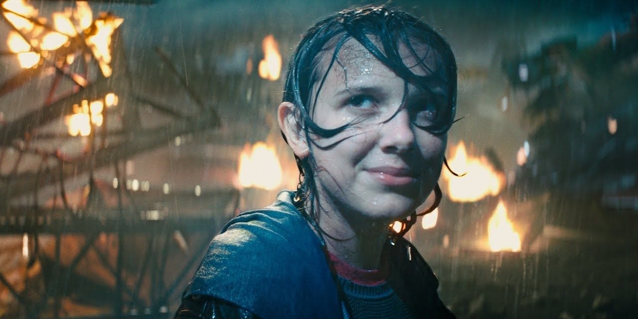 Madison Russell in the rain looking at Godzilla and smiling in Godzilla King of the Monsters