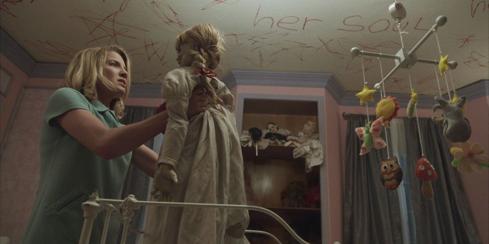 Mia holding Annabelle in a trashed room in Annabelle (2014)
