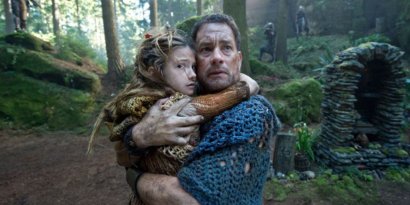 Tom Hanks holds a little girl while looking on from Cloud Atlas 