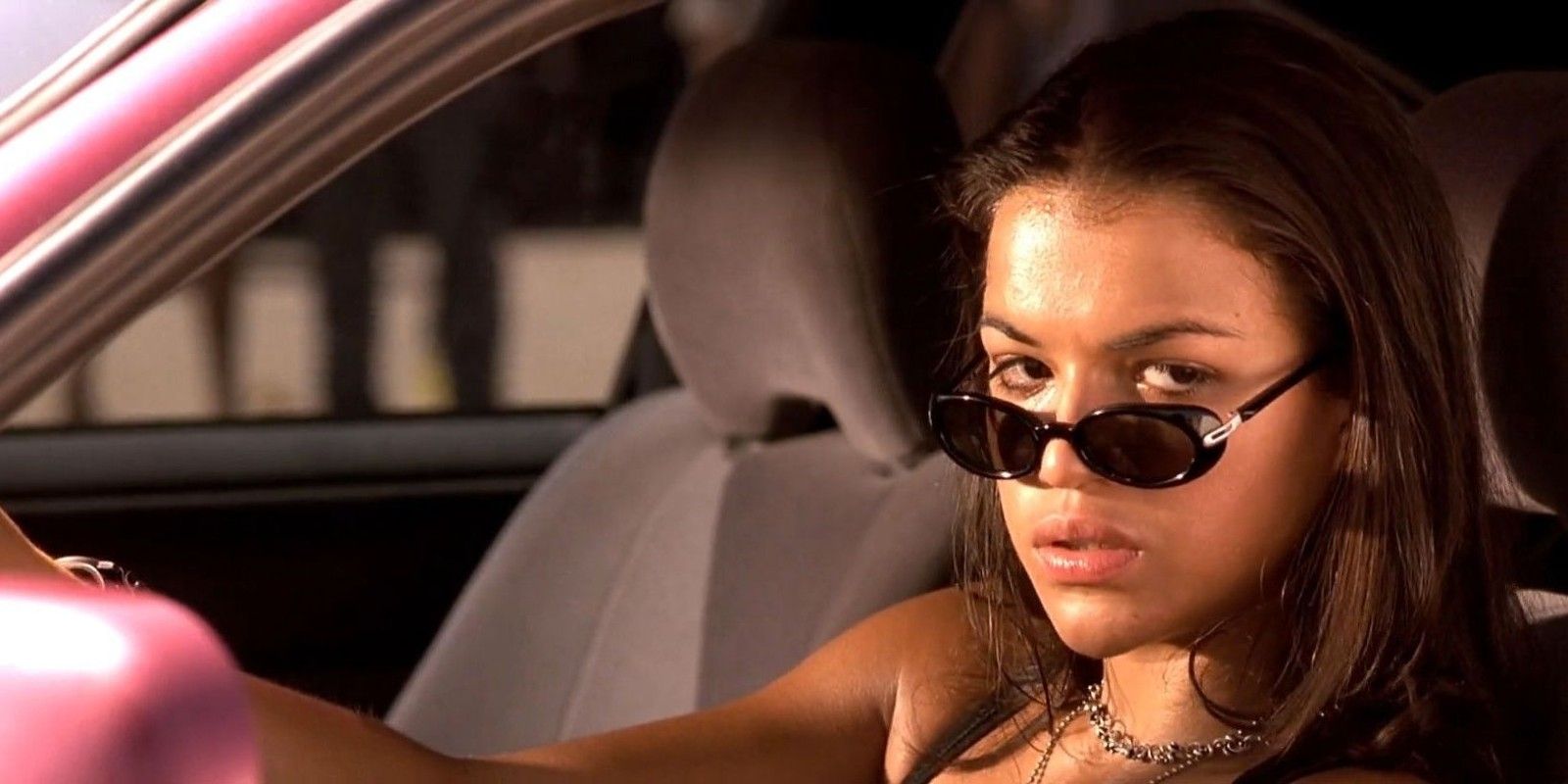 Letty looks sideways while sitting inside a car in The Fast and the Furious