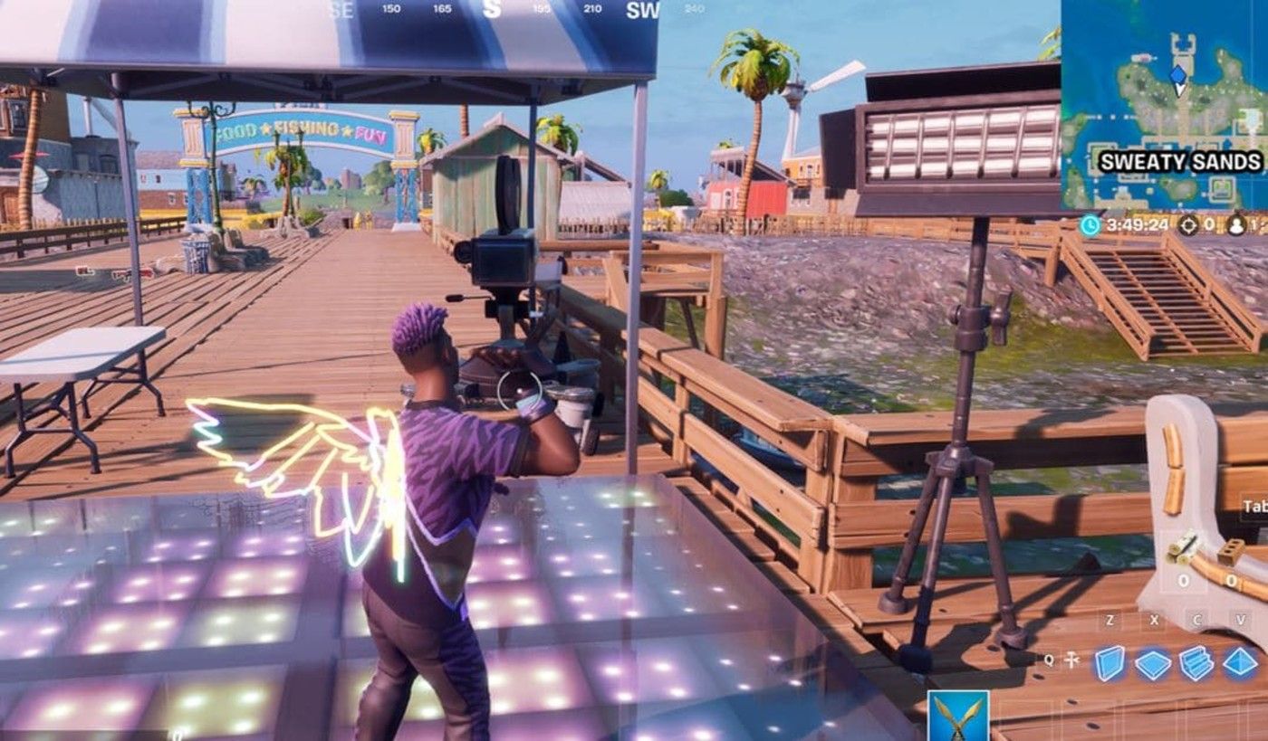 A player dances on the lit-up dance floor in front of the camera on the boardwalk at Sweaty Sands for 10 seconds to complete the Week 4 challenge in Fortnite.
