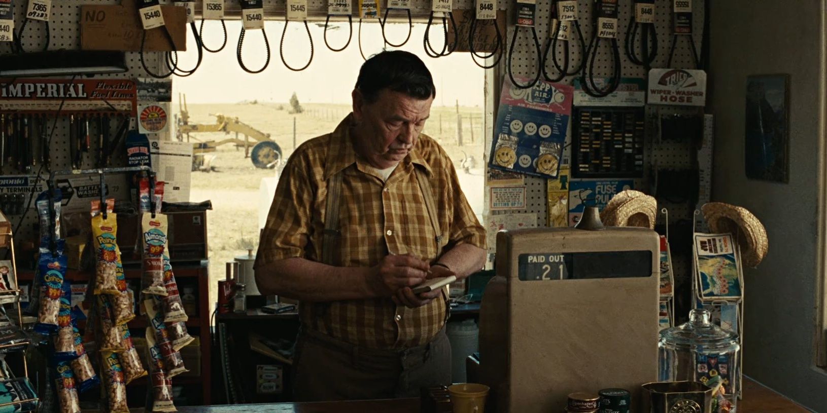 The Gas Station Attendant looking down in No Country for Old Men