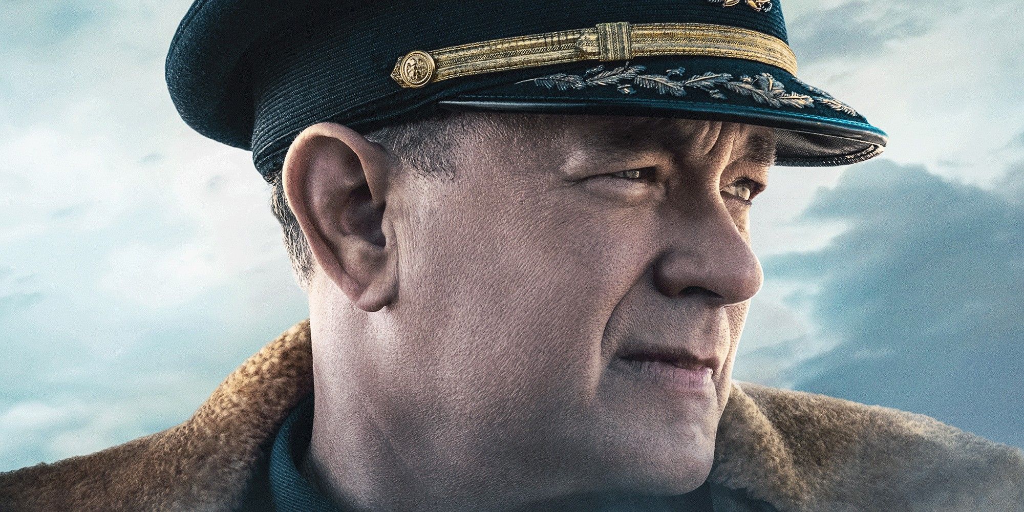 Tom Hanks as Commander Ernie Krause in a Navy commander's hat looking out to sea in Greyhound