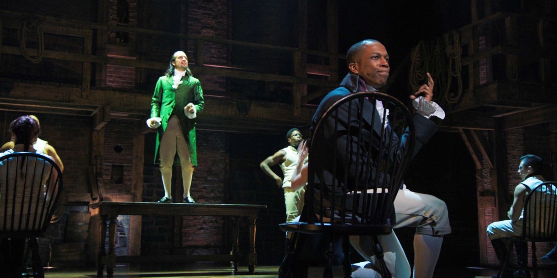 Hamilton stands on the table as Burr sings about him being non-stop in Hamilton