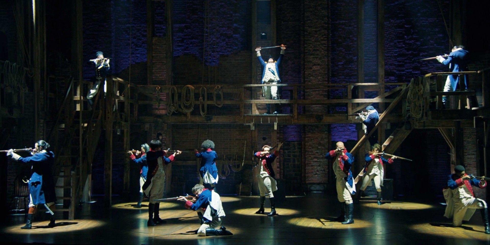 The cast of Hamilton with guns drawn across the stage as they perform "Yorktown"