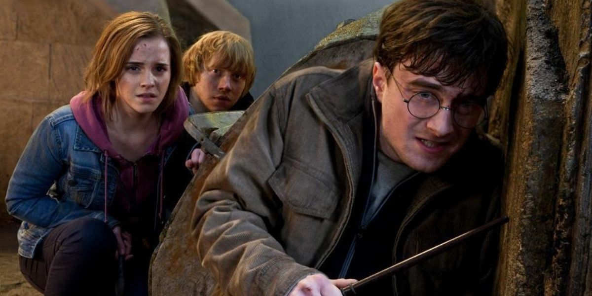 Harry, Ron and Hermione crouch around a corner in Deathly Hallows 2