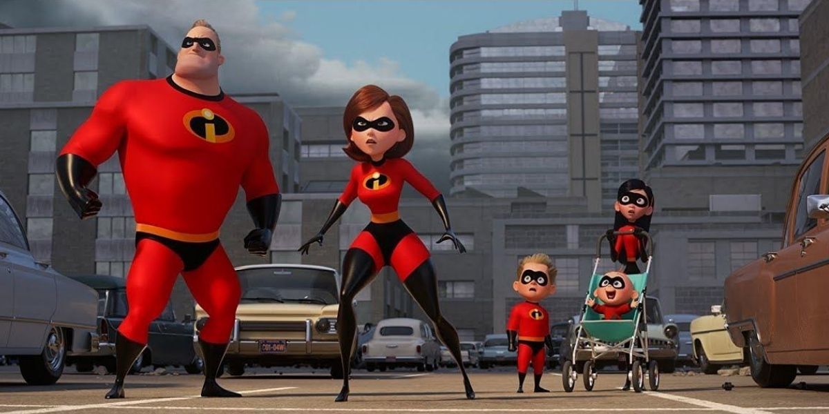 The Incredibles stand in a row wearing their costumes with Jack-Jack sitting in a pram