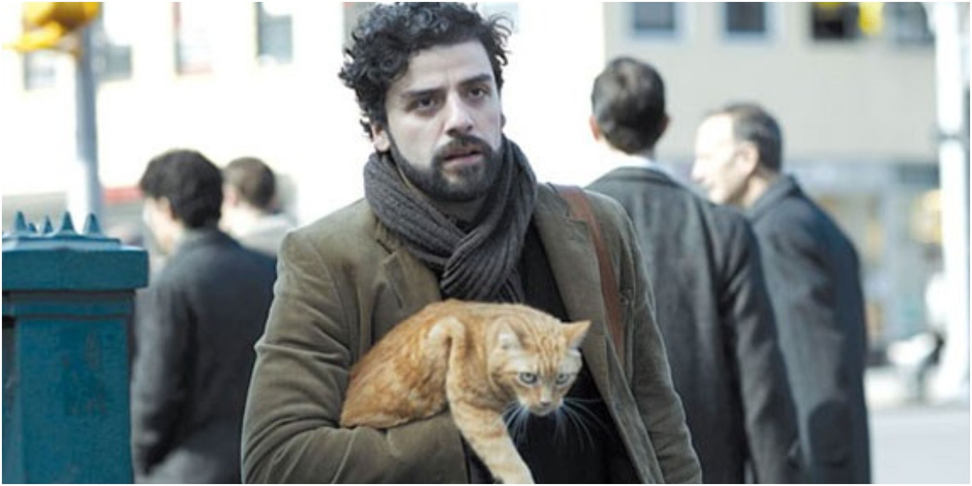 Llewyn carries Ulysses the cat through the street in Inside Llewyn Davis