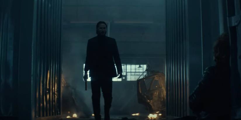 John Wick walks with a gun in his hand.