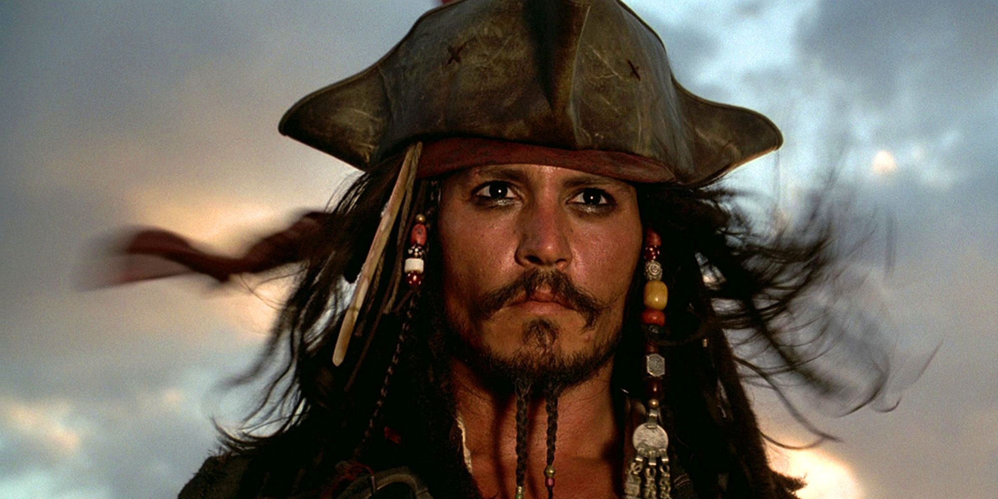 Captain Jack Sparrow standing at the mast of his ship in Pirates of the Caribbean