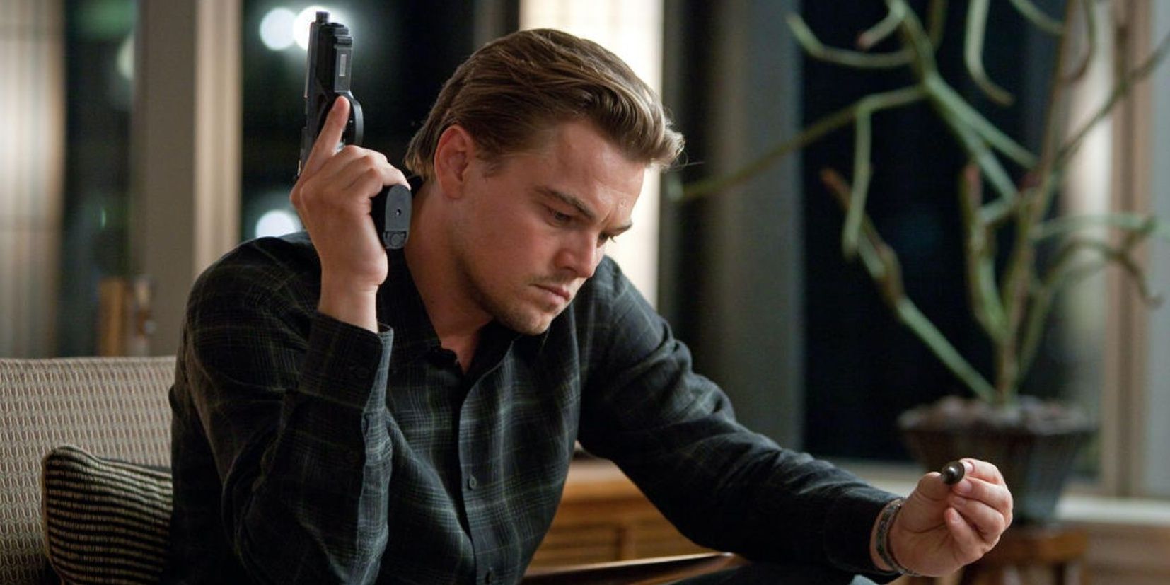 Leonardo DiCaprio holding a gun in Inception