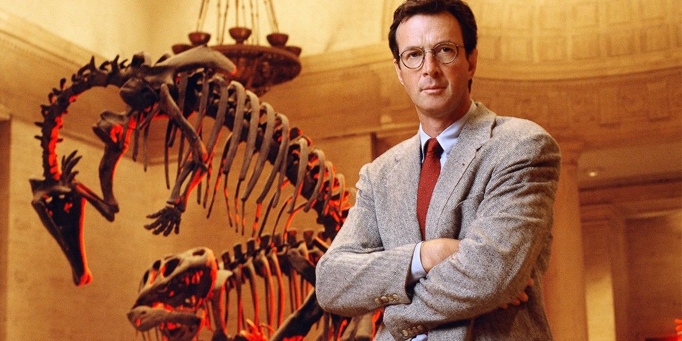 Michael Crichton in front of a dinosaur skeleton