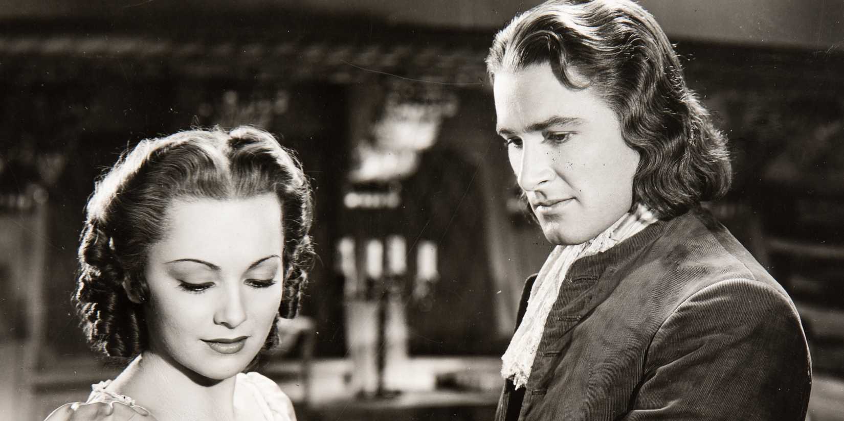 A man and woman glance down.  