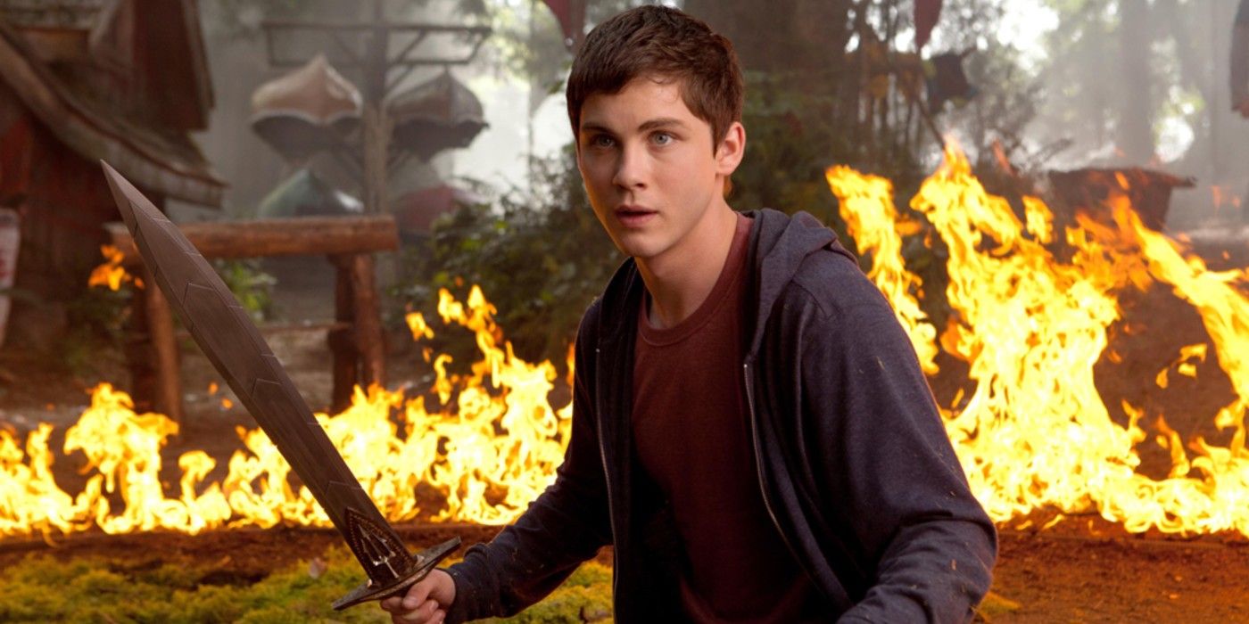Percy Jackson wielding a sword in front of a fire