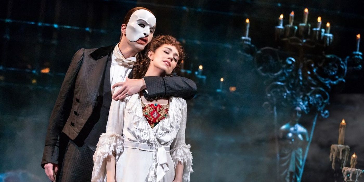The Phantom of the Opera holds Christine around the neck