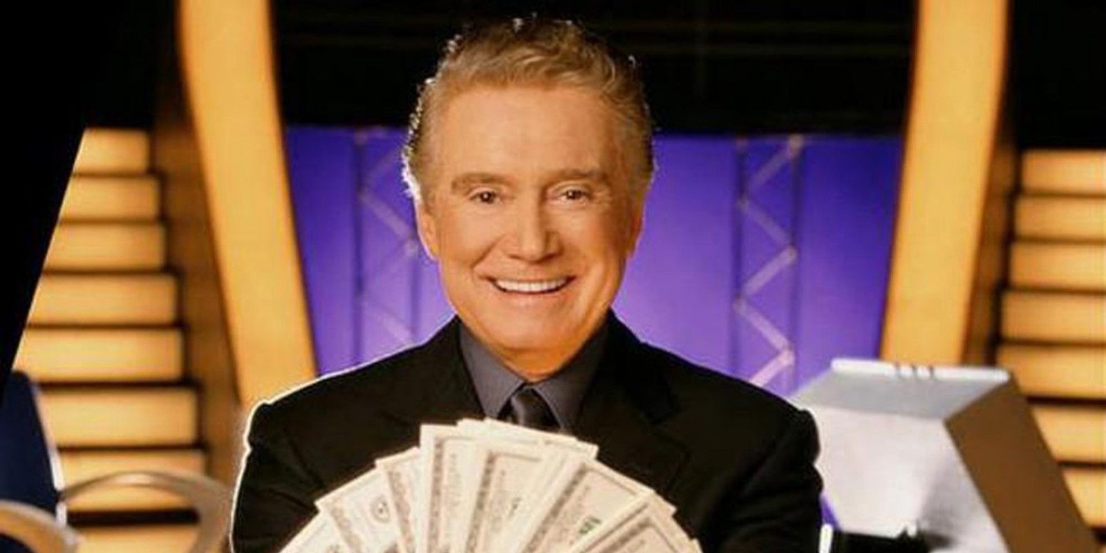Regis Philbin holding a money fan on the set of Who Wants to Be a Millionaire?