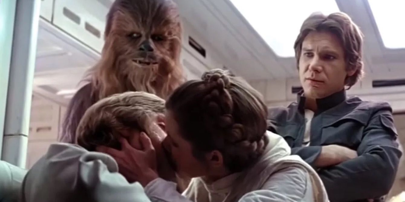 Leia grabbing Luke to plant a kiss after his Wampa attack while Han looks on in Empire Strikes Back