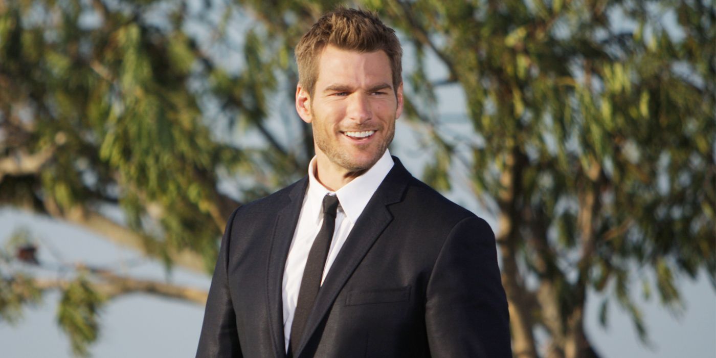 Brad Womack posing for a photo while wearing a suit and standing in front of a tree in The Bachelor