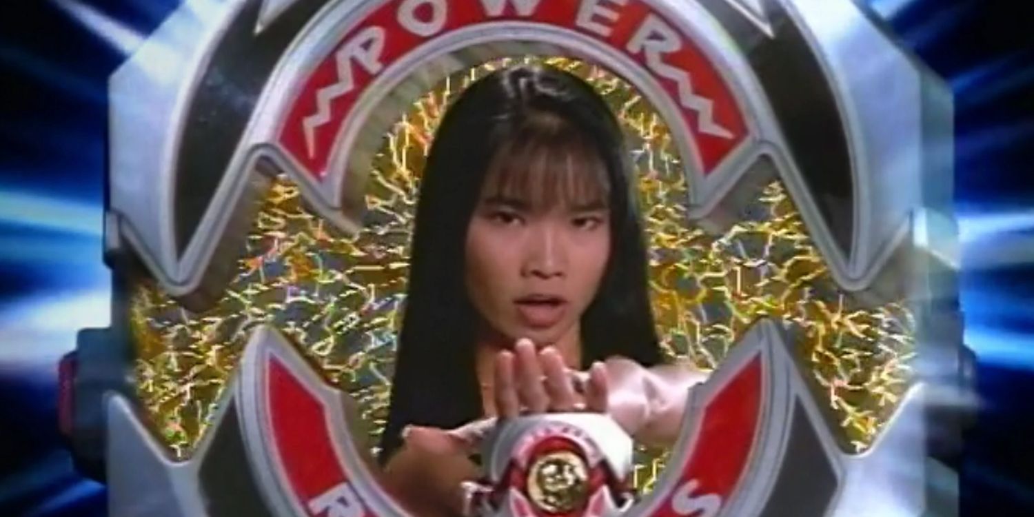 Trini holds her morpher in front of her as she calls to become the Yellow Ranger