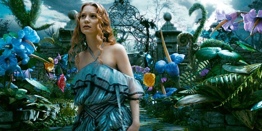 Alice walking through a garden with large plants in Alice In Wonderland.