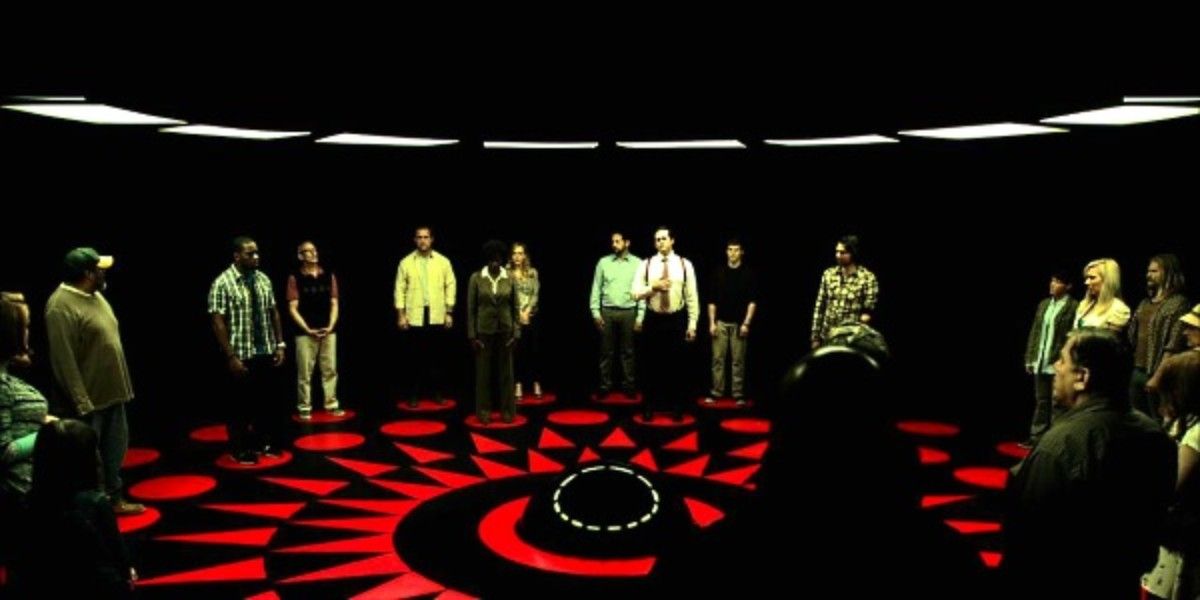 A group of people form a circle in a dark room in the movie Circle