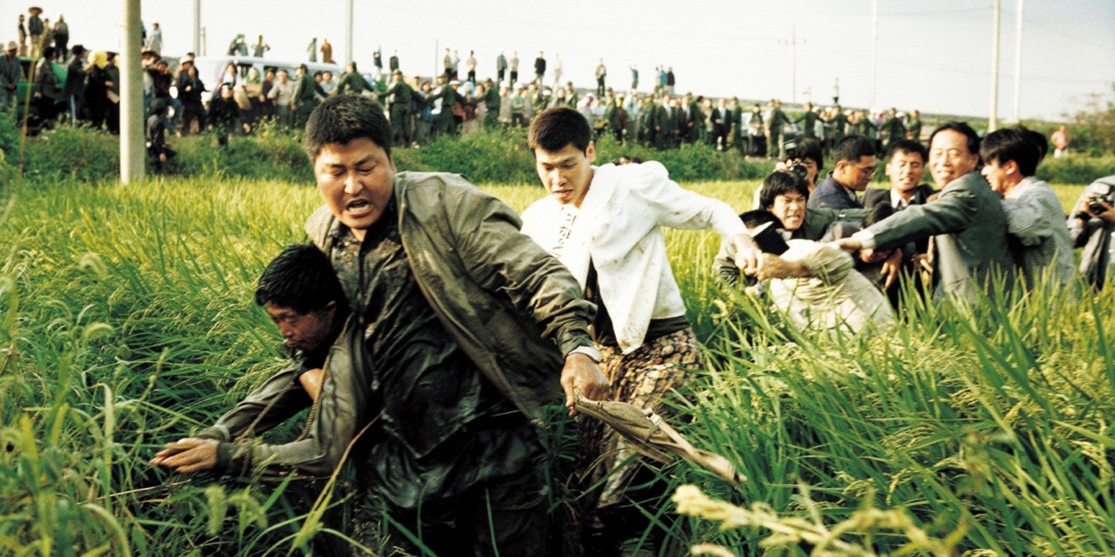 kang song-ho dragging suspect through a field in Memories of Murder