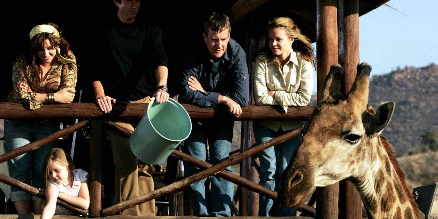 The cast of Wild at Heart feeding a giraffe