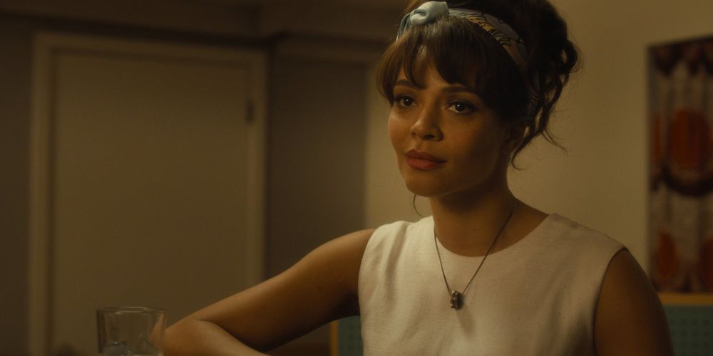 Carmen Ejogo looking towards the camera in a white dress