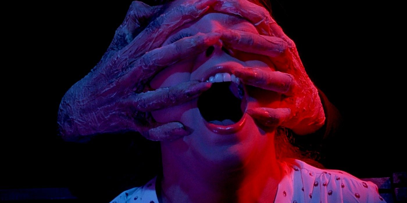 Hands over someone's face, lit by neon lights, in Dario Argento's Inferno