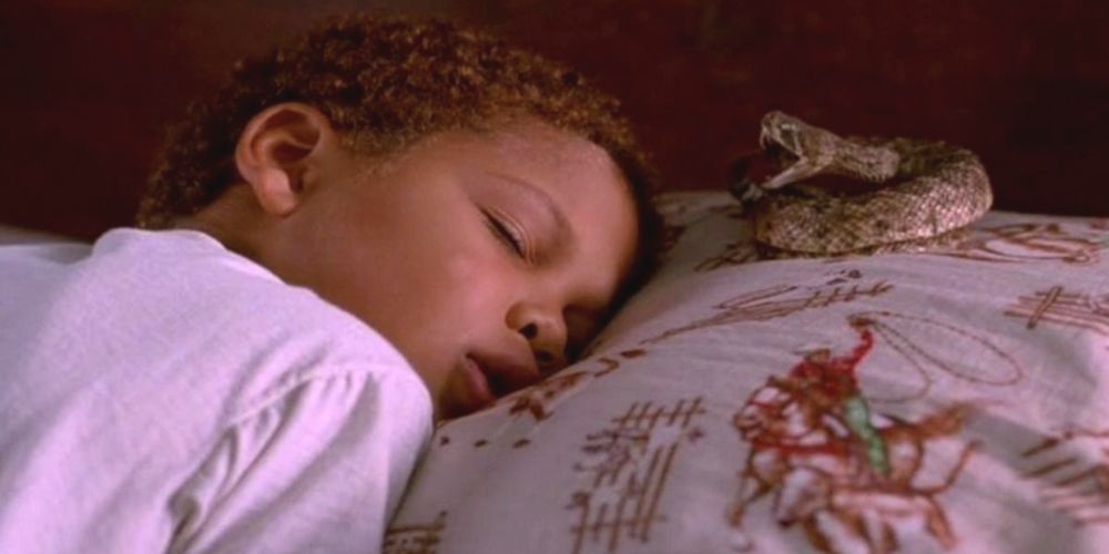 A young Journee Smollett sleeping with a rattlesnake on her pillow in Eve's Bayou