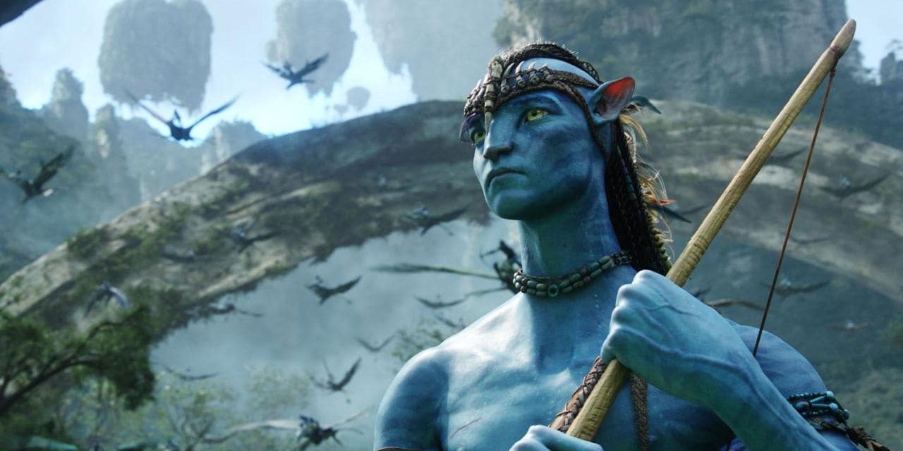 A Navi stands on Pandora with a weapon in Avatar