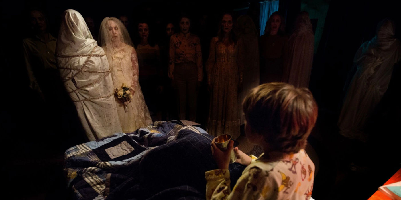 Child on Bed Surrounded by Ghosts in Insidious Chapter 2 