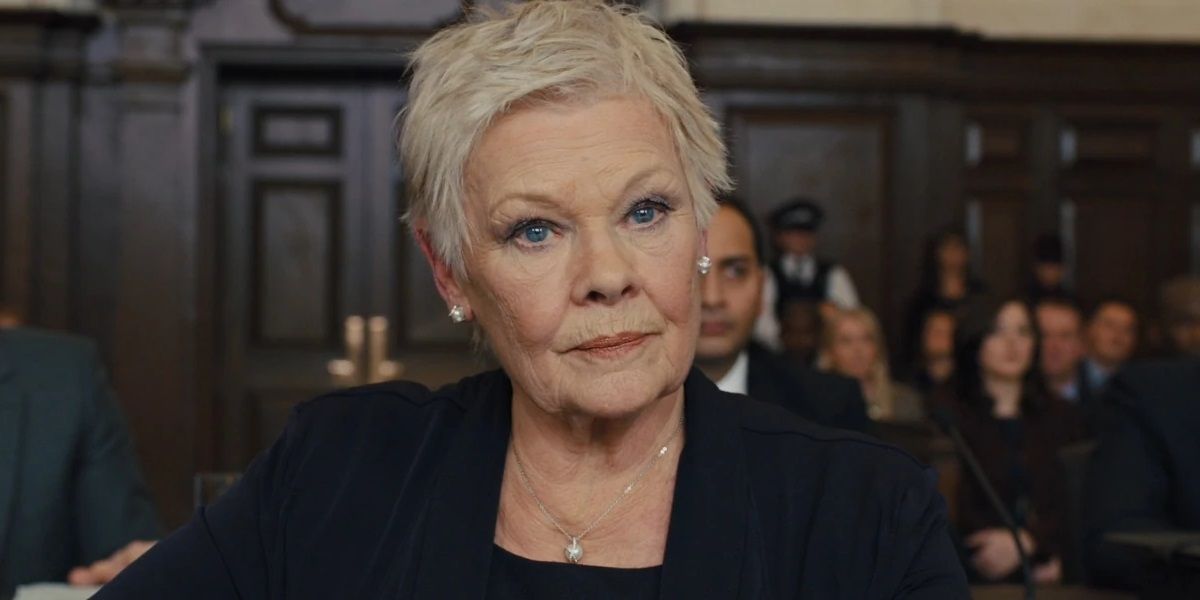 Judi Dench as M sitting in a courtroom in Skyfall.