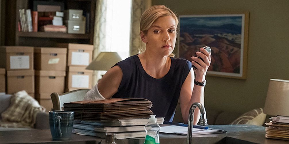 Kim Wexler at desk piled high with papers, talking into tape recorder in Better Call Saul
