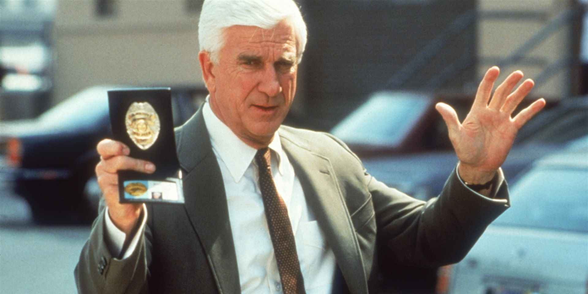 Frank holds up his badge in The Naked Gun