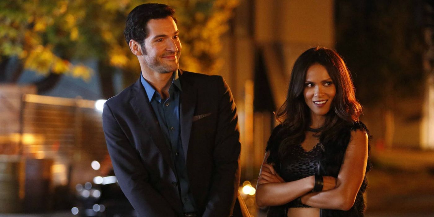 Lucifer and Maze standing together, her arms folded and him smiling.