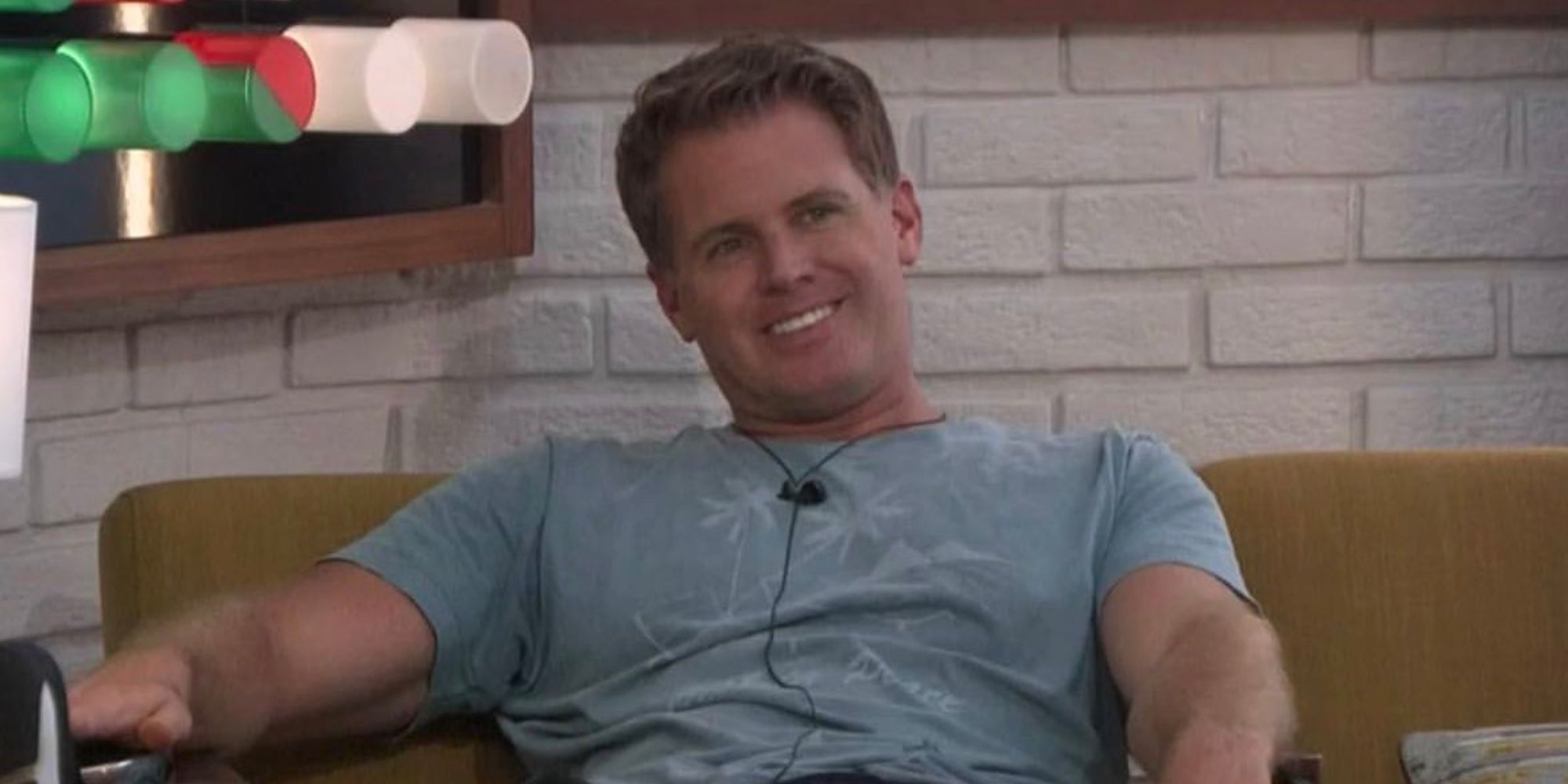 Memphis sitting in a chair in the Big Brother house, smiling widely.