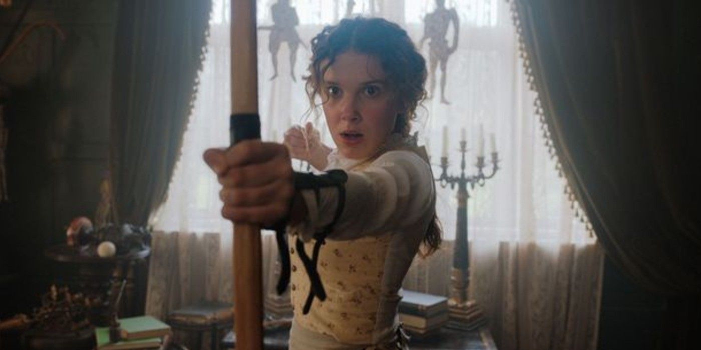Millie Bobby Brown as Enola Holmes with a bow and arrow