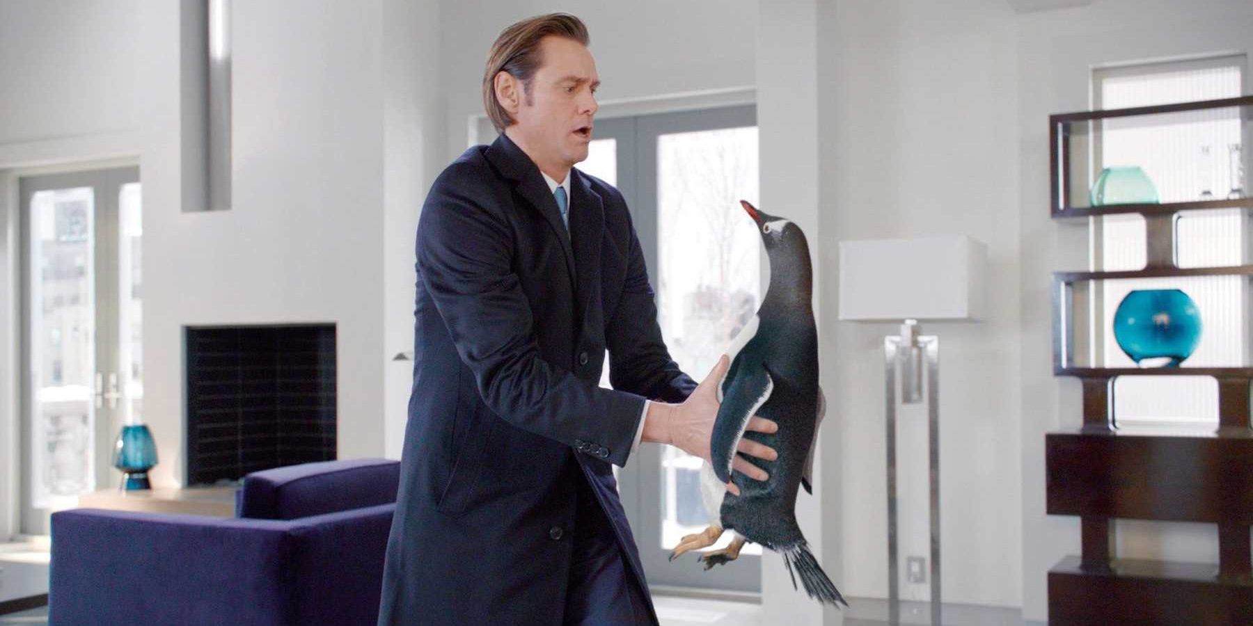 Jim Carrey holds a penguin in Mr. Popper's Penguins