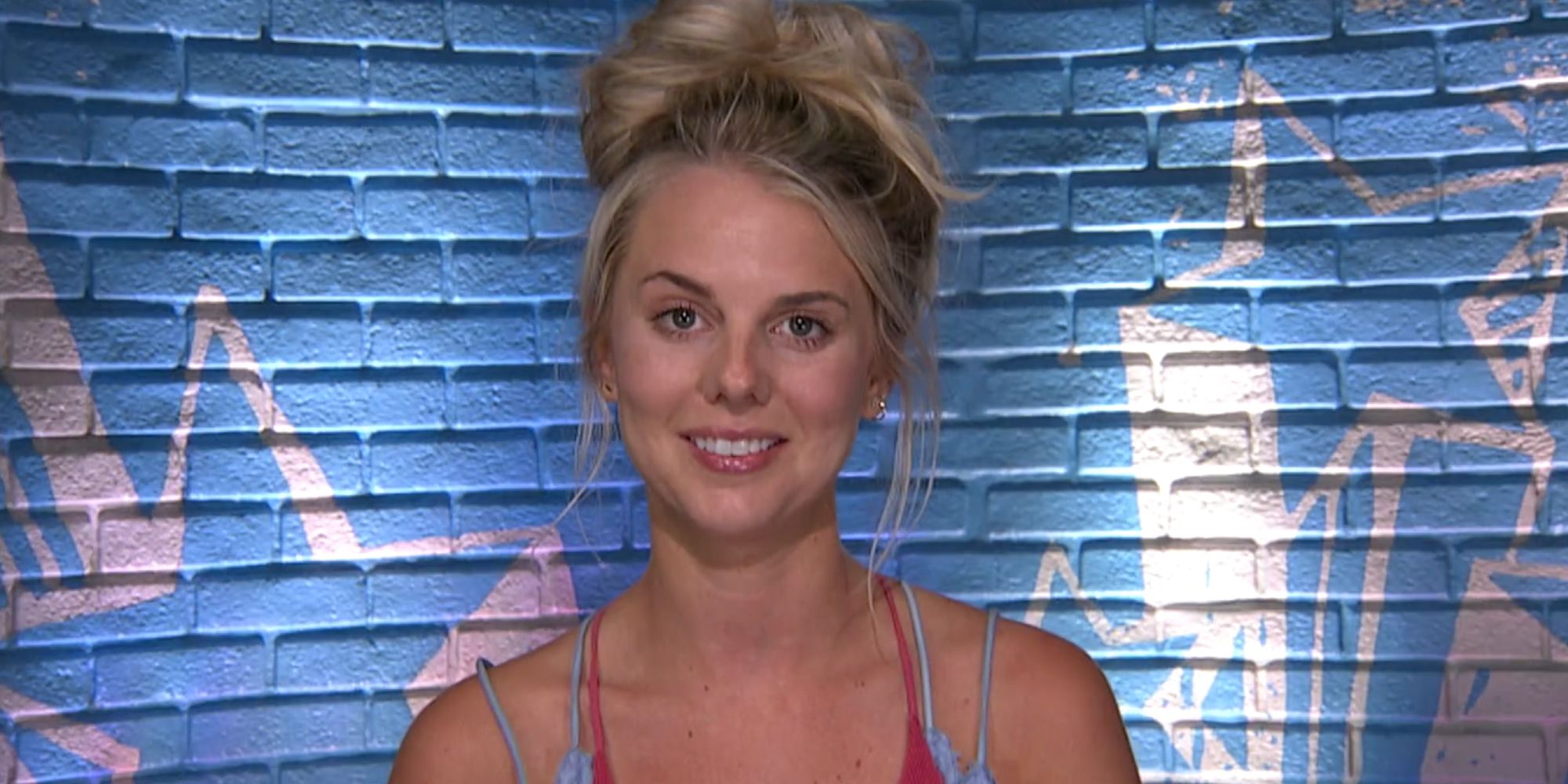 Big Brother's Nicole Franzel in the Diary Room smiling, hair in a messy bun