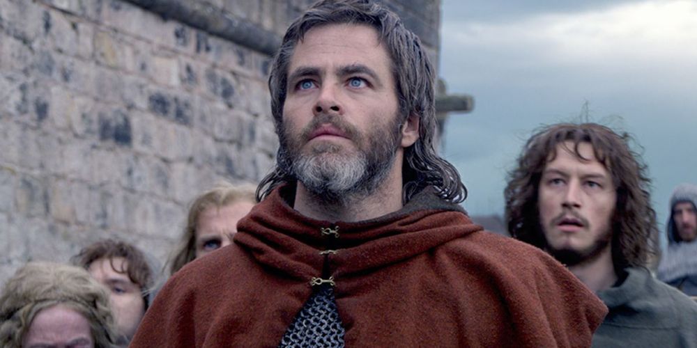 Edward standing outside a wall in Outlaw King