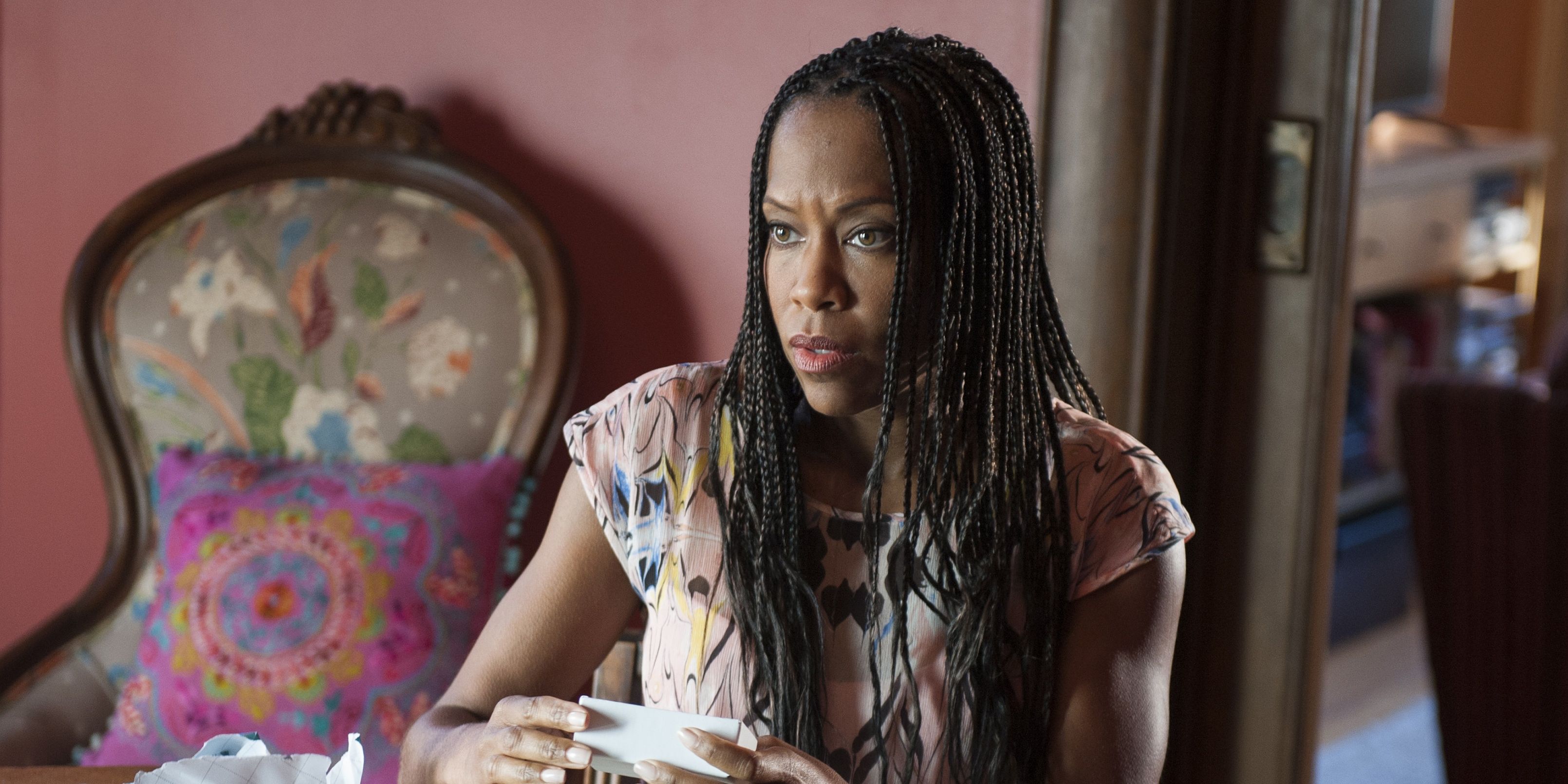 Regina King sits at a table in The Leftovers, looking disturbed.