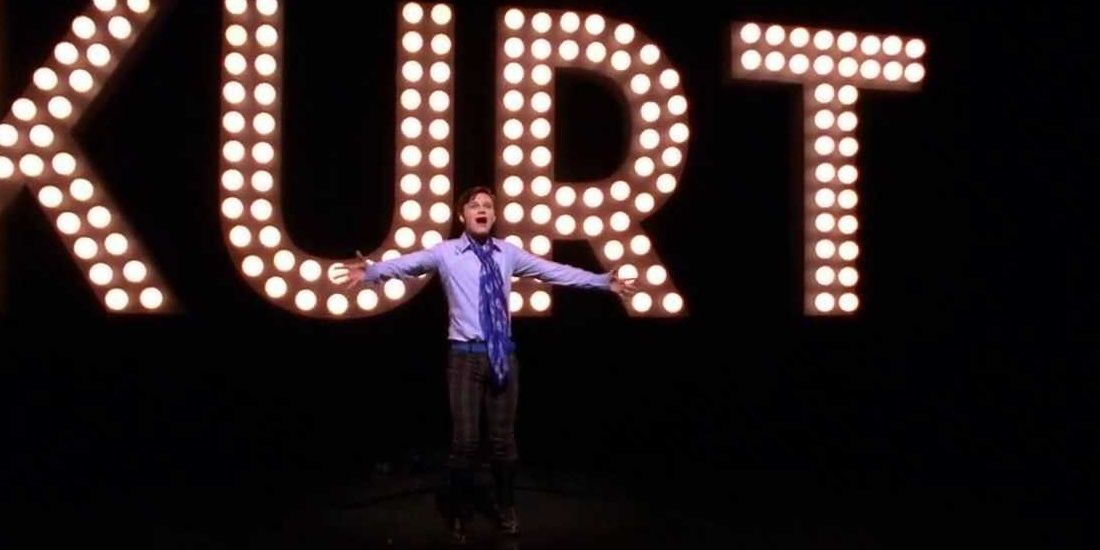 Kurt Hummel performing Rose's Turn with a large &quot;Kurt&quot; sign behind in Glee