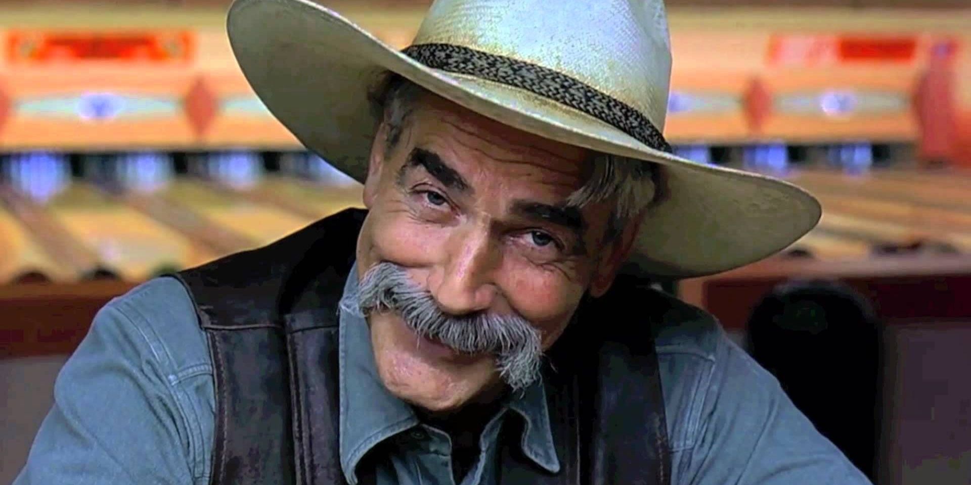 Sam Elliott sitting at the bar looking at the camera in The Big Lebowski