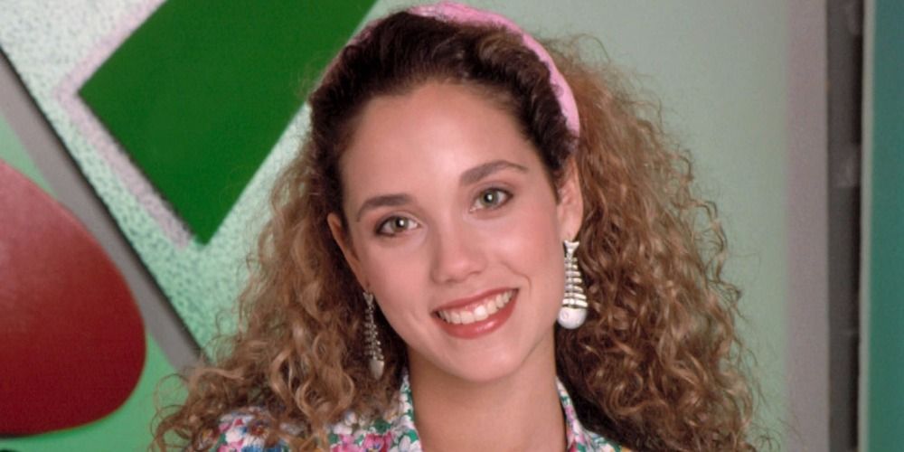 Jessie smiles in front of a geometric background for Saved By The Bell