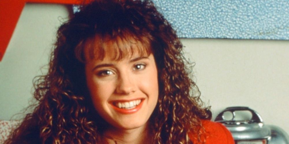 Tori sits at a booth at the Max in Saved By The Bell