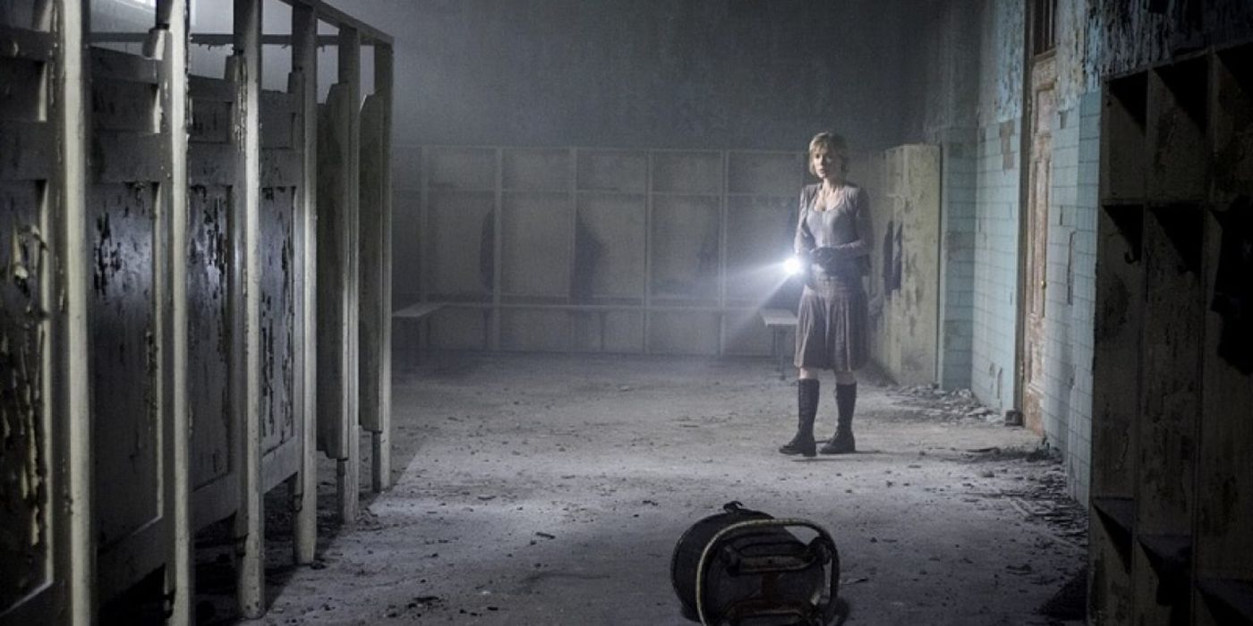 Rose holding a flashlight in a bathroom in Silent Hill 