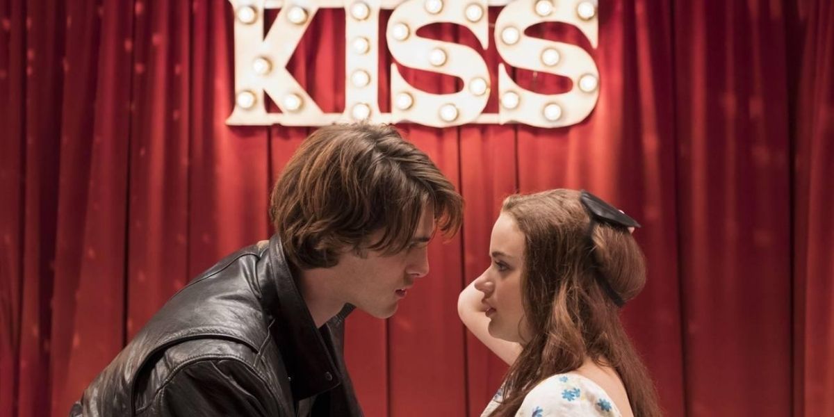 A man and a woman about to kiss in The Kissing Booth.