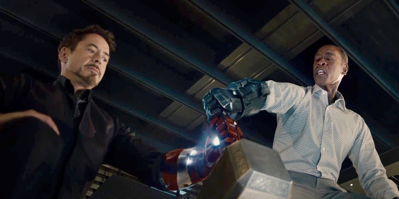 Tony e Rhodey tentam dar vida ao martelo de Thor com a ajuda das peças do braço do Homem de Ferro em Avengers: Age of Ultron