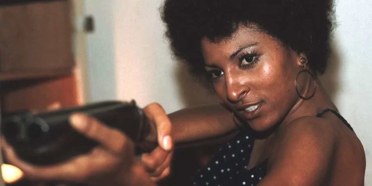 Pam Grier points a gun at an offscreen person in the 1973 film Coffy.